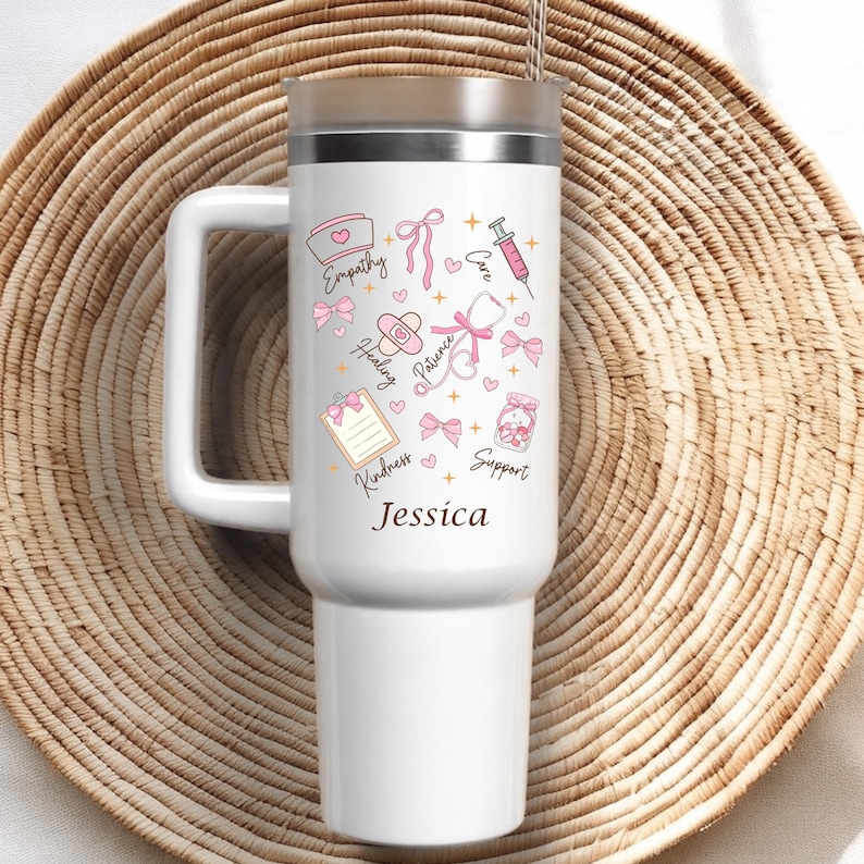 Custom nurse tumbler with personalized name, white insulated travel mug featuring pink bows, nurse cap, syringe and stethoscope artwork
