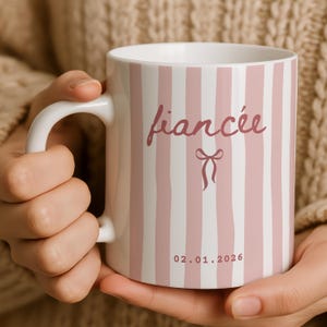Close up of fiancée mug with custom wedding date held in hands, cozy lifestyle photo