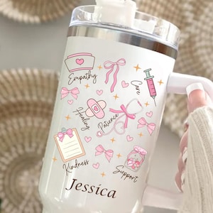 Personalized nurse tumbler with name, white 40oz insulated travel mug featuring pink nursing icons, bows, hearts and stethoscope design.