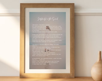 May include: A framed print with a blue and white background featuring a poem titled "Footprints in the Sand". The poem is about a person walking along a beach with God and noticing that there is only one set of footprints during the most difficult times. The poem ends with the words "It was then that I carried you."