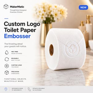 May include: A white roll of toilet paper featuring a circular embossed logo of a cube inside a hexagon. The text reads MakerMatic, Custom Logo Toilet Paper Embosser, The finishing detail your guests will notice, Ink-Free, Reusable, Custom Logo, Precision Embossing, Functional Objects, Beautifully Made, Designed & Made by MakerMatic, Proudly Designed in California.