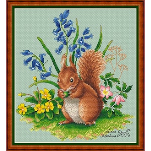 May include: A cross-stitch pattern featuring a brown squirrel sitting in a field of bluebells and yellow flowers. The squirrel is holding a nut in its paws. The background is a light blue.
