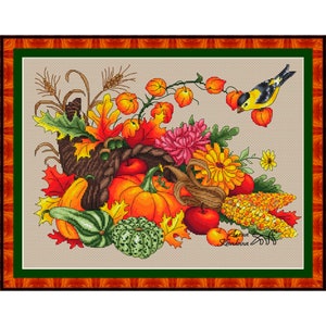 Könnte beinhalten: Ein Kreuzstichmuster mit einem Füllhorn, das überquillt mit herbstlichen Ernteprodukten wie Kürbissen, Kürbissen, Mais, Äpfeln und Herbstlaub. Ein kleiner gelber Vogel sitzt auf einem Zweig mit roten Beeren.