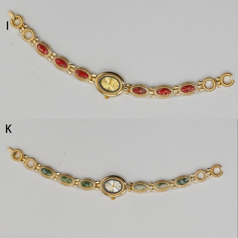 Puede incluir: Dos relojes de pulsera dorados. Uno presenta una esfera dorada y detalles de piedras rojas, el otro una esfera plateada y detalles de piedras verdes. Ambos relojes tienen esferas ovaladas y correas de eslabones dorados a juego.