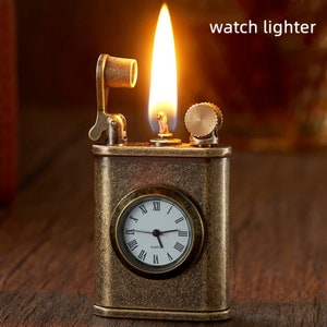May include: A vintage-style, brass-colored lighter with a built-in watch face. The lighter has a flame coming out of the top and a lever on the side. The watch face is white with black Roman numeral markings and says "QUARTZ" at the bottom.