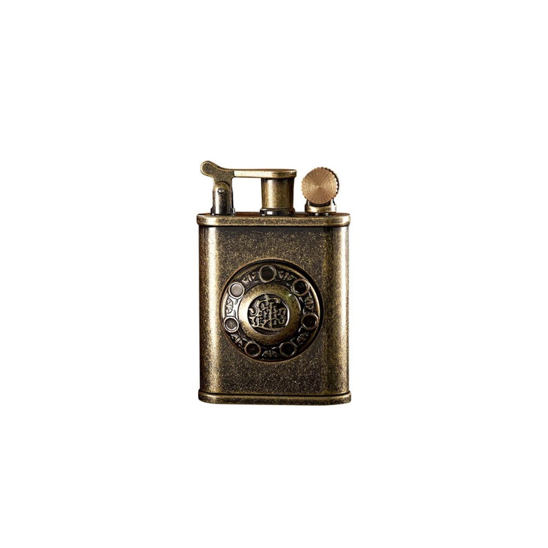 May include: A vintage-style, brass lighter with an ornate design and a small knob on the top. The lighter has a textured surface and a circular emblem with Chinese characters in the center.