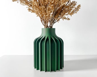 May include: A dark green ceramic vase with a fluted design. The vase is filled with dried brown flowers.
