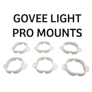 Puede incluir: Seis soportes blancos Govee Light Pro. Los soportes son cuadrados con esquinas redondeadas y pequeños agujeros en los lados. El texto "GOVEE LIGHT PRO MOUNTS" se muestra en negrita, en letras negras encima de los soportes.