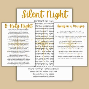 May include: Three Christmas carols are displayed on white paper: "Silent Night," "O Holy Night," and "Away in a Manger." The text is in a classic serif font, with the title "Silent Night" in a gold, decorative font.
