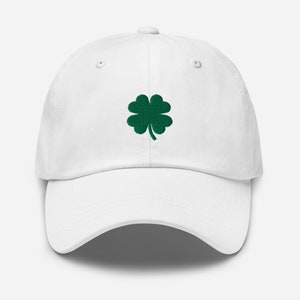 May include: A white baseball cap with a green four-leaf clover embroidered on the front.