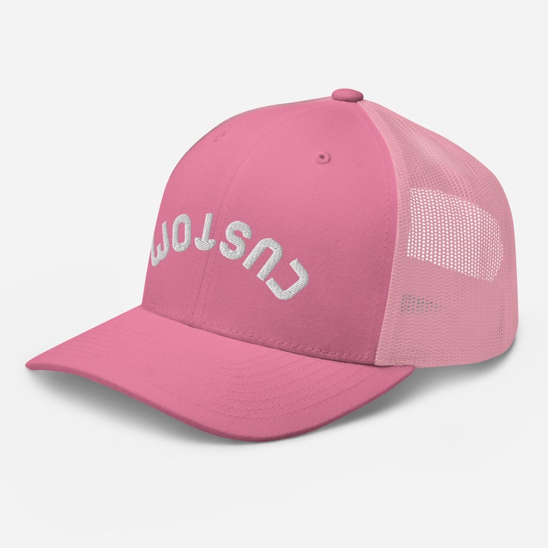 Pu&ograve; includere: Cappellino da camionista rosa con logo "CUSTOM" ricamato in bianco.
