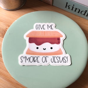 May include: A green round sticker with a cartoon s'more and the text "Give me s'more of Jesus!"