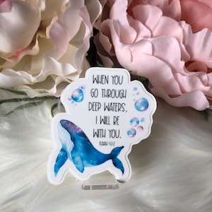 May include: A white whale with blue and purple watercolor design on a white background with the text "WHEN YOU GO THROUGH DEEP WATERS, I WILL BE WITH YOU. ISAIAH 43:2" and blue and white bubbles.