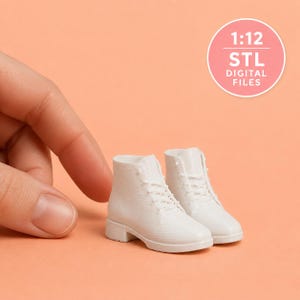 May include: A pair of miniature white lace-up boots with a low heel and textured surface. The boots are labeled as 1:12 STL digital files, indicating they are designed for 3D printing at a one-twelfth scale for dollhouse or hobbyist projects.
