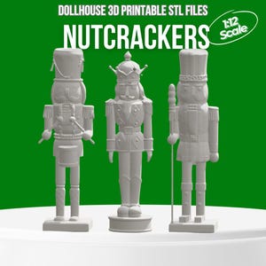 以下が含まれることがあります： 1:12スケールの白いくるみ割り人形のフィギュア3体。それぞれユニークなデザインです。「DOLLHOUSE 3D PRINTABLE STL FILES」と「NUTCRACKERS」の文字が上部にあります。背景は緑色です。