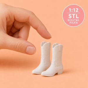May include: A pair of miniature white cowboy boots in a 1:12 scale, featuring a classic pointed toe, a mid-calf shaft, and a small block heel. The item is presented as 1:12 STL digital files for 3D printing, showing a smooth, solid white finish.
