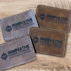 May include: Four brown leather business cards with the text "INNOVATIVE ELECTRICAL SYSTEMS, INC." and the logo "IES" in a compass design. The text "Honest. Professional. Affordable" is also included on each card.