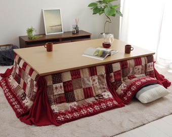 Puede incluir: Un futón de parches rojo y blanco con una mesa de madera en la parte superior. El futón tiene un borde rojo y un diseño estampado blanco y rojo. La parte superior de la mesa es de madera y tiene un acabado marrón claro.