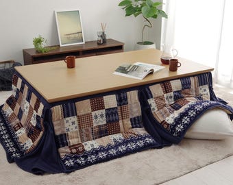 Puede incluir: Una mesa de madera con un futón de color azul y marrón estampado debajo. El futón tiene una almohada blanca en la parte superior. Hay dos tazas y una revista en la mesa.
