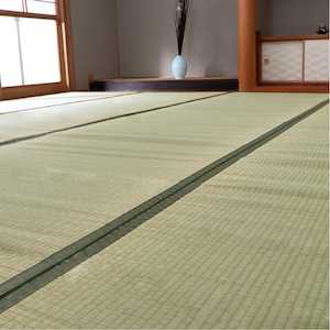 May include: A close-up of a light green tatami mat with dark green edging. The mat is made of woven rush and is commonly used in traditional Japanese homes.