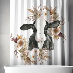 May include: A white shower curtain with a black and white cow illustration surrounded by brown and white flowers. The cow is looking directly at the viewer.