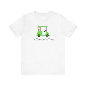 May include: White t-shirt featuring a green golf cart graphic with the text "It's Tee-quila Time". The golf cart has black wheels and a steering wheel. The shirt is made of a soft, comfortable material.