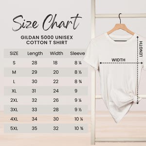 May include: A white Gildan 5000 unisex cotton t-shirt hanging on a wooden hanger. To the left is a size chart with measurements in inches for length, width, and sleeve for sizes S through 5XL. The chart includes the text "Size Chart".