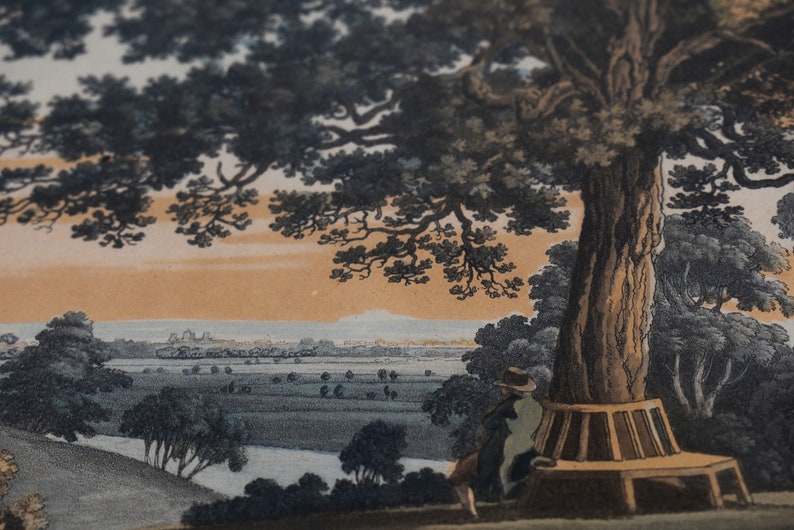 May include: An antique print depicting a landscape scene with a large tree in the foreground. A person sits on a bench beneath the tree, looking out at a distant town. The sky is a soft orange and blue.