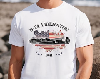 May include: White t-shirt with a distressed American flag design and a B-24 Liberator airplane silhouette. The text "B-24 LIBERATOR" is printed in black above the design, and "1941" is printed below.
