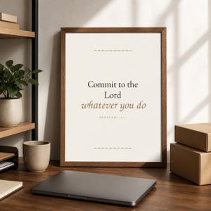 May include: A framed wall art print featuring the text Commit to the Lord whatever you do, with the citation Proverbs 16:3 below it. The print has a cream background, dark text, and two small decorative horizontal line accents in brown.