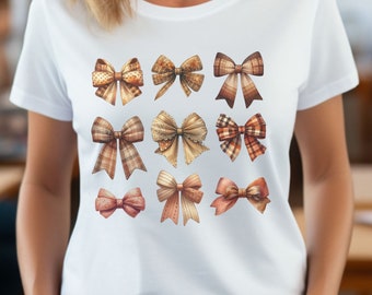 以下が含まれることがあります： 9つの茶色とベージュのリボンがデザインされた白いTシャツです。