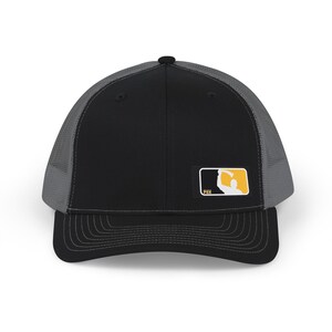 May include: A black and gray baseball cap with a structured front panel and mesh back. A rectangular patch on the front features a yellow and black logo depicting a silhouette of a person holding an object, with the text "WILDER FUN" below.
