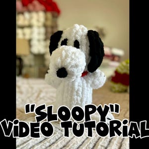 May include: A handmade white and black plush dog with a red collar. The dog has black ears and black spots around the eyes. The text "Sloopy" Video Tutorial is written in a cartoon font.