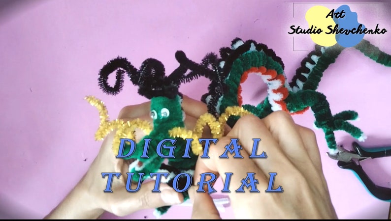 Puede incluir: Dos dragones verdes de limpiapipas, uno con rayas blancas y negras y el otro con cuernos negros, est&aacute;n siendo sostenidos por manos. El texto "DIGITAL TUTORIAL" est&aacute; en letras azules sobre un fondo rosa.