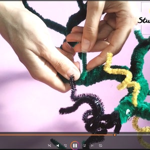 Puede incluir: Un drag&oacute;n de limpiapipas verde, amarillo y negro est&aacute; siendo ensamblado. El drag&oacute;n tiene una cola larga, alas y una cabeza con ojos. El drag&oacute;n est&aacute; siendo sostenido por las manos de una persona. El texto "Art Studio Shevchenko" es visible en la esquina superior derecha de la imagen.