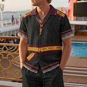May include: A short-sleeved button-down shirt and matching shorts set in black with a dark gray textured pattern. The outfit features horizontal bands of yellow and maroon with geometric arrow designs, a maroon collar, and a small rectangular patch.