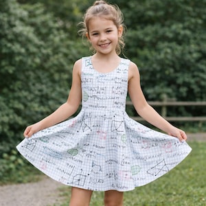 May include: A sleeveless dress featuring a white grid pattern overlaid with black mathematical equations, geometric diagrams, and small green and red accents. The dress has a fitted bodice and a flared skirt that reaches above the knees.