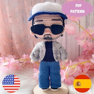 Puede incluir: Muñeco de ganchillo con gorro blanco y azul, gafas de sol, chaqueta gris, camisa azul marino y pantalones azules. El muñeco tiene una pequeña barba y está sobre una superficie de madera. Incluye el texto "PDF PATTERN".