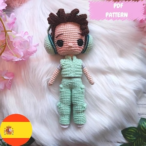 Puede incluir: Una muñeca amigurumi de crochet con cabello castaño, vestida con ropa verde y auriculares. La muñeca está sentada sobre una superficie blanca y esponjosa. El texto "PDF PATTERN" es visible en la esquina superior derecha de la imagen.