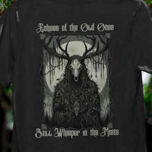 Peut inclure: T-shirt noir avec une illustration détaillée d'une créature avec des bois et un visage en forme de crâne, entourée de vignes. Le texte "Echoes of the Old Ones" et "Still Whisper in the Mists" est imprimé au-dessus et en dessous du dessin.
