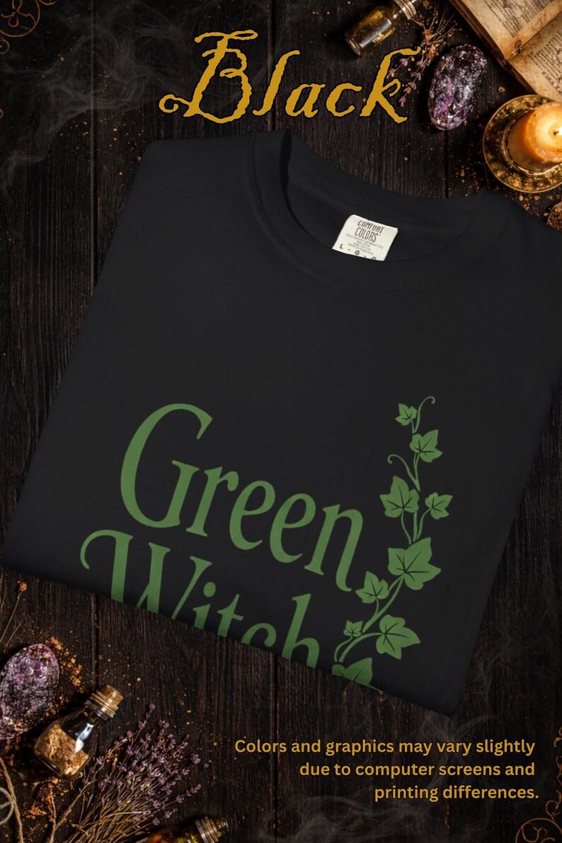 Peut inclure: Sweat-shirt noir avec l'inscription "Green Witch" en vert, accompagn&eacute;e d'un motif de lierre vert. Le mot "Black" est &eacute;crit en or en haut. Le texte "Colors and graphics may vary slightly" est en bas.