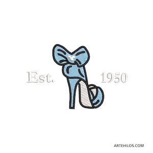 Puede incluir: Un zapato azul de tacón alto con un lazo en la parte superior y un strass. El texto "Est. 1950" está a ambos lados del zapato.