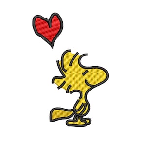 Puede incluir: Parche bordado con Woodstock, un personaje de pájaro amarillo, con un corazón rojo encima. El diseño tiene contornos negros y está sobre un fondo blanco. El parche es probablemente para ropa o accesorios.