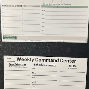 May include: Two rectangular magnetic weekly command centre planners with white backgrounds and black text. The top planner includes sections for top priorities, a weekly schedule, a running to-do list, and meals. The bottom planner features sections for top priorities, schedule events, and a to-do brain dump.