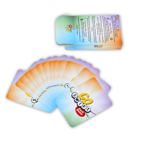 May include: A deck of "Go Swift" card game cards fanned out, with a box in the background. The cards have a colorful design with the game's logo and text. The box displays game instructions.