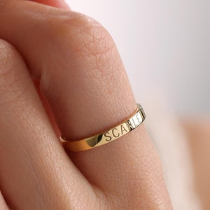 May include: A gold band ring with the word "SCARLETT" engraved on the band.