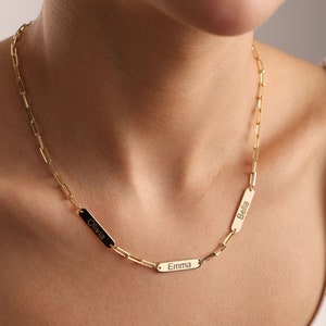 Op de afbeelding: Gouden ketting met drie rechthoekige naamplaatjes. De naamplaatjes zijn gegraveerd met de namen "Olivia", "Emma" en "Bella".