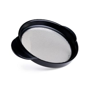 May include: Black round strainer with a fine mesh screen. The strainer has a lip around the edge and a small handle on the side.