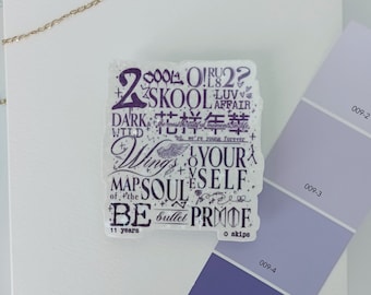 May include: A clear, rectangular sticker with purple text featuring the words "2 COOL 4 SKOOL," "Wings," and "YOURSELF." The sticker is on a white surface with a gold chain and a purple color swatch.