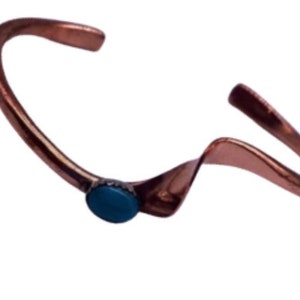 May include: A copper bracelet with a turquoise stone accent. The bracelet is open and has a wavy design.